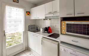 a small kitchen with white cabinets and a window at Maison Piriac in Piriac-sur-Mer