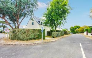 a white house with a hedge in front of a street at Maison Piriac in Piriac-sur-Mer