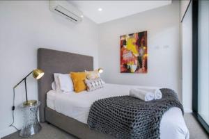 a bedroom with a large white bed with pillows at Bright CBD 2 bedroom resort-style escape in Brisbane +8 photos