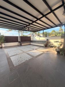 a patio with a large roof with a table and chairs at Casa Permai Temerloh in Temerloh