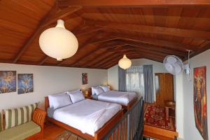 a bedroom with two beds and a couch at O'Neill's Cottage in Dikkapitiya