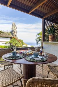 a table on a patio with a view of the ocean at Pousada Morena in Fernando de Noronha