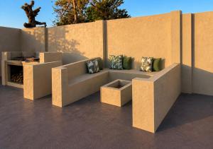 a couch with pillows sitting next to a wall at Gold Pepper Boutique Guesthouse in Siyabuswa