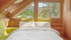 a bedroom with a bed and a large window at Seogwipo Neulbada Pet Pension in Seogwipo