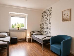 a room with two beds and a chair and a window at Apartments am Heimbach EG rechts in Kassel