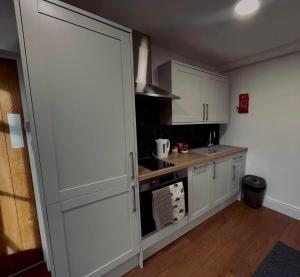 a kitchen with white cabinets and a counter top at Rutland Point in Uppingham +13 photos
