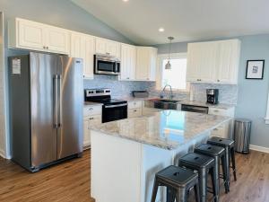 a kitchen with white cabinets and a stainless steel refrigerator at 3 4 Time in Holden Beach