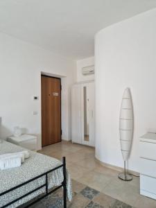 a white room with a bed and a surfboard in it at Il Giardino in Pietrelcina