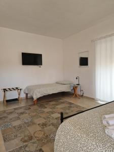 a room with two beds and a flat screen tv at Il Giardino in Pietrelcina
