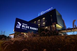 een blauw racismebord voor een gebouw bij Blue Rabbit Hotel in Chanthaburi