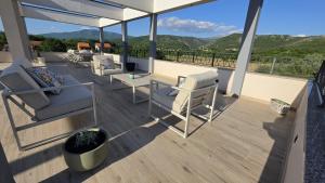 a balcony with chairs and a table and a view at Villa Jelena Rooms and Apartments in Kovačić