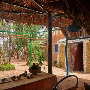 a building with a table with bowls and bells on it at Traditional Berber Eco Farm Stay in Agadir