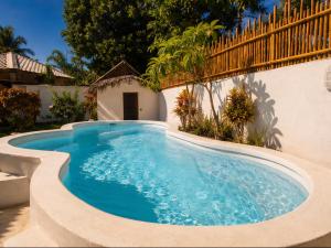 a swimming pool in the side of a house at Les Bungalows De Ja in Nosy Be