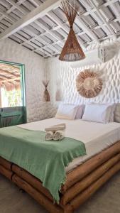 a bedroom with a bed with two towels on it at Villa Água Viva in Itarema +60 photos