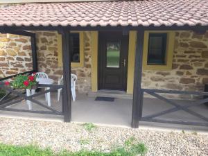a stone house with a black door and a table and chairs at ubytovaní na statku  +7 photos