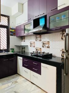 a kitchen with purple cabinets and a counter top at The Commune Varanasi in Varanasi