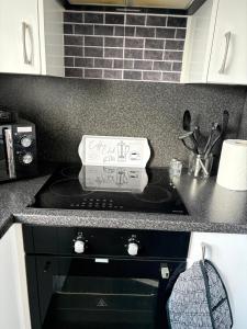 a kitchen with a stove with a sign on it at The M Rooms at 158 in Shotts Station