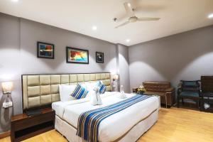 a bedroom with a large bed and a chair at Bluestone Nehru Place by The Cosy Hotels in New Delhi