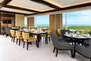 a dining room with tables and chairs and large windows at Vila Gale Reserva do Paiva in Cabo de Santo Agostinho +16 photos