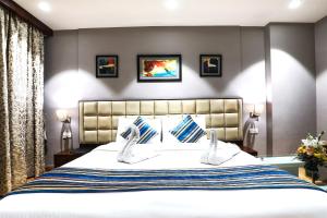 a bedroom with a large bed with two white shoes at Bluestone Nehru Place by The Cosy Hotels in New Delhi