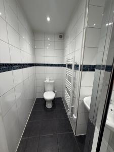 a white bathroom with a toilet and a sink at Rutland Point in Uppingham