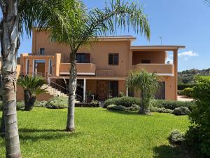 a house with palm trees in front of it at Casa Altoliva in Marsala