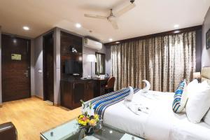 a hotel room with a bed and a desk at Bluestone Nehru Place by The Cosy Hotels in New Delhi