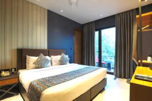 a bedroom with a large bed and a window at Bluestone Nehru Place by The Cosy Hotels in New Delhi +25 photos