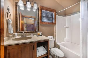 a bathroom with a sink and a toilet and a tub at Yellowstone Valley Lodge, an Ascend Collection Hotel in Pray +127 photos