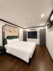 a bedroom with a large white bed and a window at Hanoi Silk Crown Boutique Hotel & Spa in Hanoi