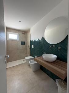 a bathroom with two toilets and a sink and a mirror at Da Jaco in Castellammare del Golfo +67 photos