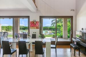 a dining room with a table and chairs and a piano at Villa Sara in San Costanzo