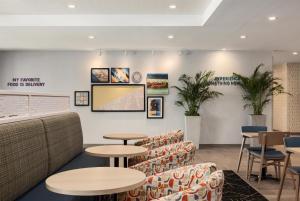 a waiting room with tables and chairs at Home2 Suites By Hilton Springfield in Springfield