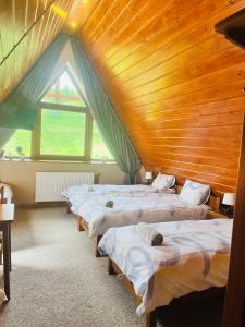 a row of beds in a room with a wooden ceiling at Chracowka in Małe Ciche +49 photos