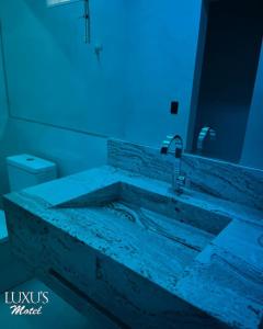a bathroom with a tub and a sink with a blue light at Luxus Motel Caldas do Jorro in Tucano