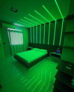 a green bedroom with a bed with a green ceiling at Luxus Motel Caldas do Jorro in Tucano