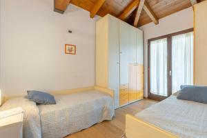 a bedroom with two beds and a large window at Villa Sara in San Costanzo +26 photos