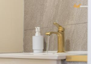 a bathroom sink with a faucet and a bottle of soap at 2Br House I Sleeps 4 I Cumbernauld in Cumbernauld +38 photos