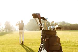 a man standing in a field with a golf clubs at L'Escale Royale Torcy - Marne la Vallée in Torcy