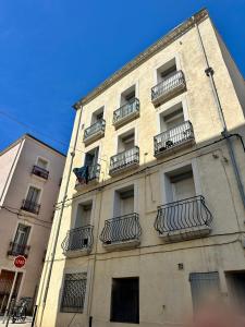 a tall building with balconies on the side of it at The Rave in Sète