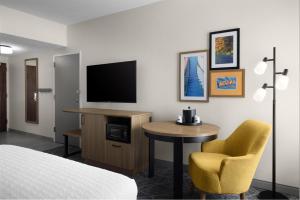 a hotel room with a bed and a table and a television at Hampton Inn Terre Haute in Terre Haute