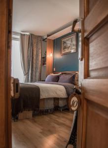 1 dormitorio con 1 cama con paredes azules en Private room in Parisian couple's Home - Close to it all!, en París