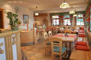 a restaurant with tables and chairs and a kitchen at Bauernhof Hoenigshof in Fischbach