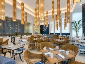 a restaurant with tables and chairs and chandeliers at Vila Gale Reserva do Paiva in Cabo de Santo Agostinho
