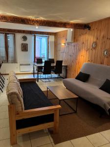 a living room with two beds and a table at Le cocon de Barcelonnette in Barcelonnette