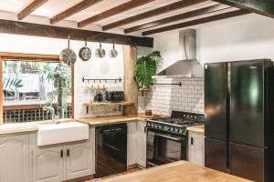 a kitchen with a refrigerator and a stove top oven at The Treehouse - Rainforest Home - Pool in Smithfield