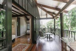 a room with a balcony with a table and chairs at The Treehouse - Rainforest Home - Pool in Smithfield +32 photos