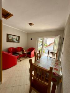 a living room with a red couch and a table at Eiffel's Guest House in Pogradec