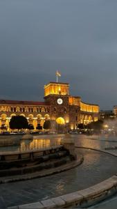 a large building with a clock tower in front of it at White Hotel in Yerevan
