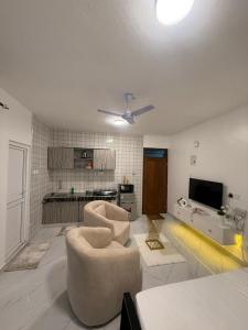 a living room with two chairs and a tv at Coastal comfort studio apartment in Mombasa